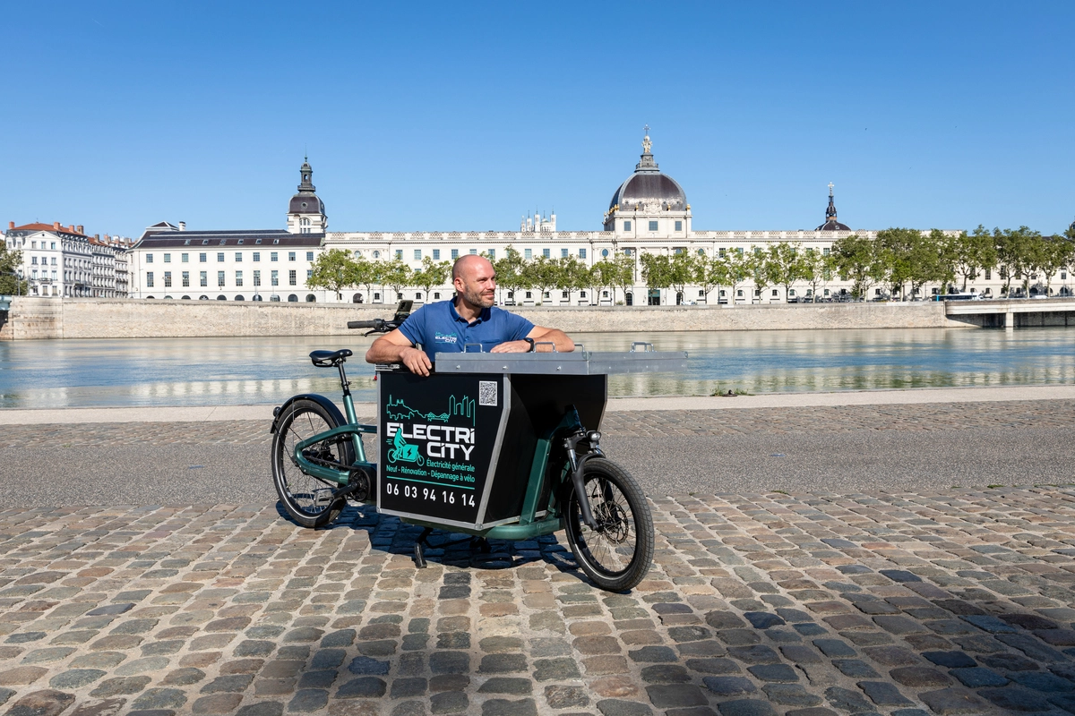 Installateur domotique utilisant un vélo cargo pour des interventions rapides et écologiques en milieu urbain.